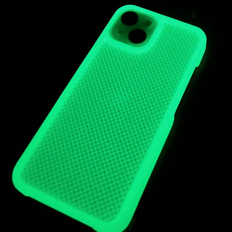 A textured glow in the dark phone case glowing bright green in a dark room