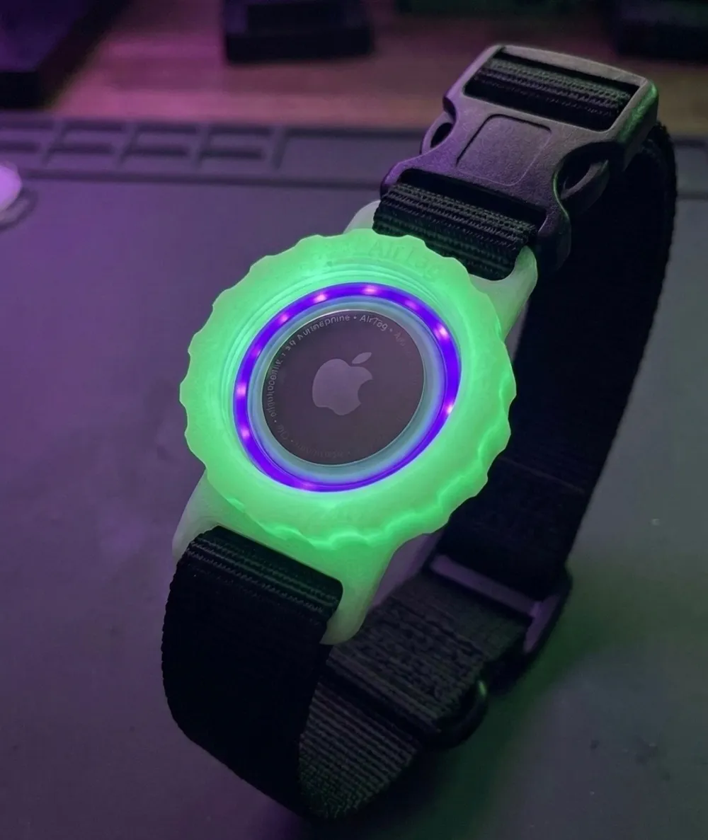 A glowing green tracker holder mounted on a black dog collar